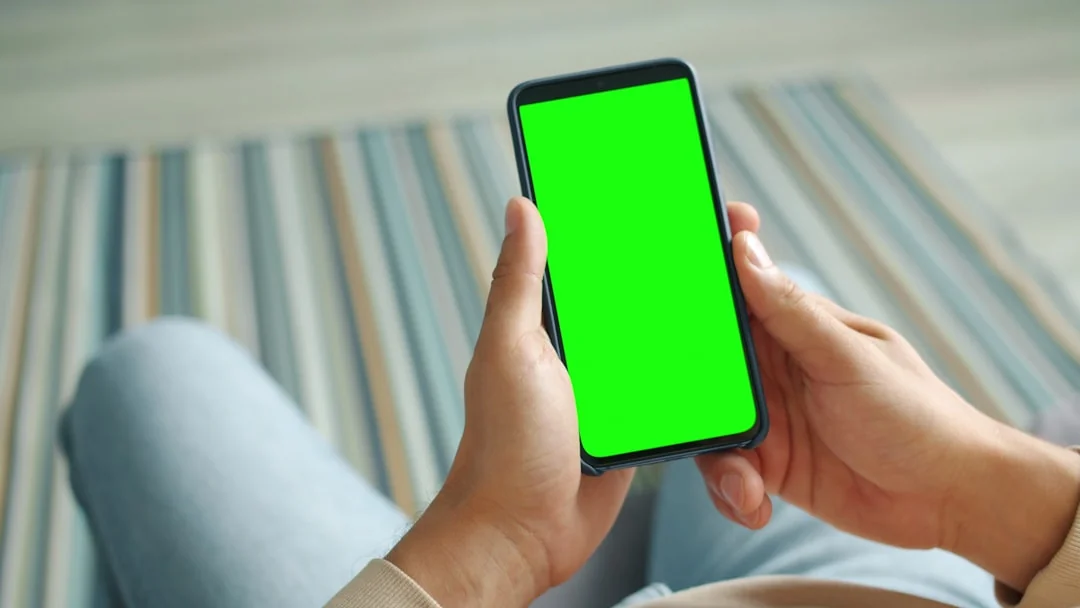 Close-up of a hand holding a note with the word CLIENT in front of a lush green leafy background.
